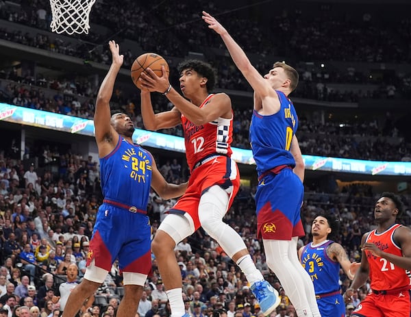 Los Angeles Clippers guard Cam Christie, center, drives to the basket between Denver Nuggets guards Jalen Pickett, left, and Christian Braun in the second half of Game 7 of an NBA basketball first-round playoff series Saturday, May 3, 2025, in Denver. (AP Photo/David Zalubowski)