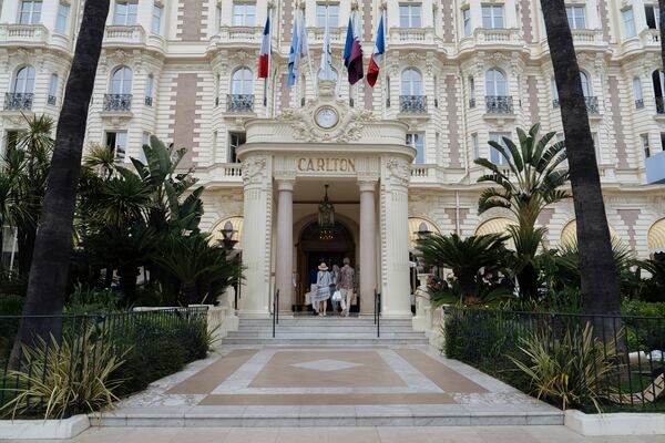 People enter the Carlton Hotel along the Boulevard de la Croisette ahead of the 78th international film festival in Cannes, southern France, Sunday, May 11, 2025. The Cannes film festival runs from May 13 until May 24, 2025. (AP Photo/Lewis Joly)