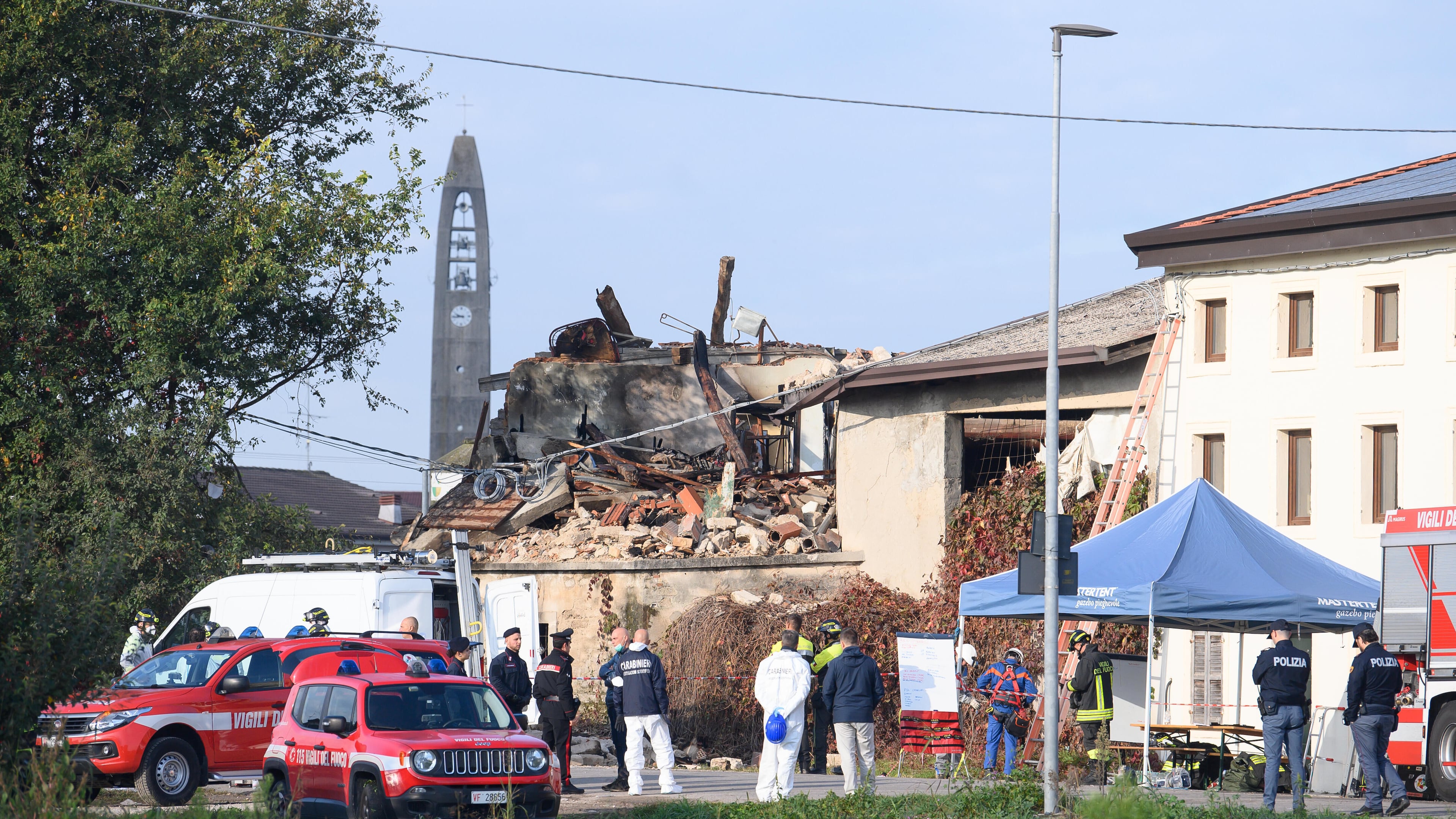 Rescuers inspect a collapsed two-story farmhouse in Castel d'Azzano, some 10 kilometers south-west of Verona, where three carabinieri officers have been killed, and 13 others injured, in an explosion during an eviction, early Tuesday, Oct. 14, 2025. (Claudio Furlan/LaPresse via AP)