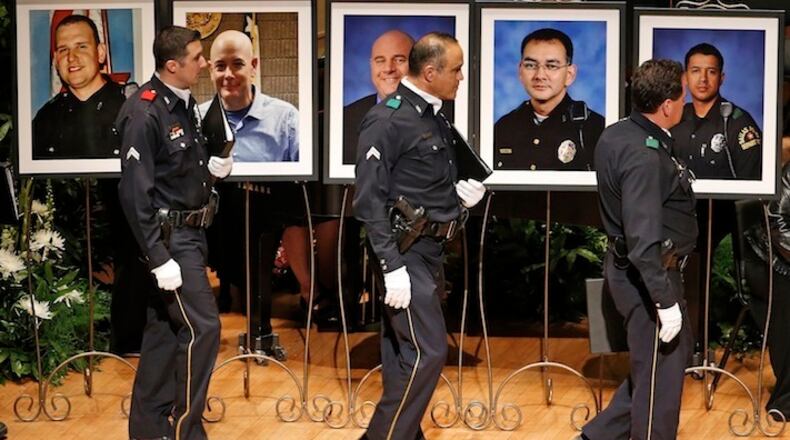 Members of the Dallas Police Department Choir walk past portraits of their fallen comrades during a memorial for five Dallas and DART police officers shot to death in July 2016. After a long summer of violence, Congress has a big job on its plate: finding new ways to mend relations between police and African-American communities across the nation. (Paul Moseley/Fort Worth Star Telegram/TNS)
