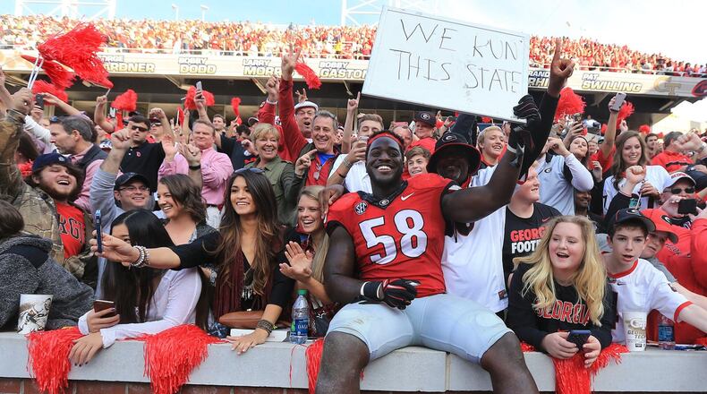 Georgia defensive tackle Sterling Bailey celebrates with UGA fans after beating Georgia Tech 13-7 on Saturday. The Bulldogs have one game remaining this season: a bowl. Curtis Compton / ccompton@ajc.com