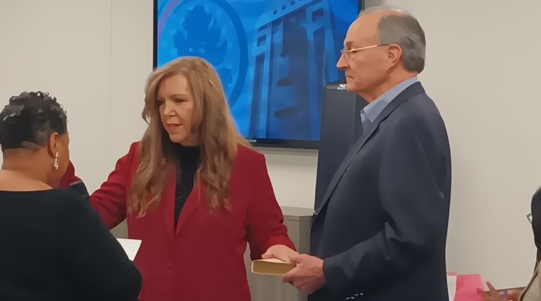 Julie Adams (center) is sworn in as a member of the Fulton County Board of Registration & Elections on Feb. 8. Clerk of Courts Che' Alexander (left) administers the oath, and Mike Heekin, Adams' fellow Republican board member, holds a Bible.