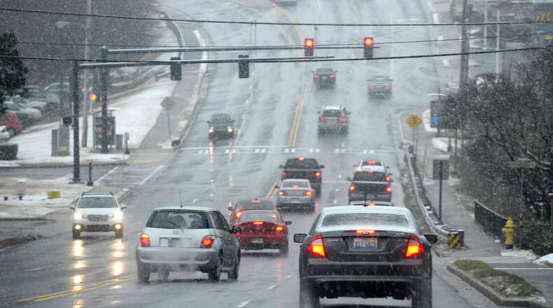 Motorists drive through a wintry mix of snow, sleet and rain, Tuesday, Feb. 24, 2015, in Atlanta. The University of Georgia's Gwinnett campus delayed their opening while further west, the Cobb County school system canceled classes and weather forecasters predicted another round of winter weather for Wednesday. (AP Photo/David Tulis)