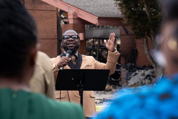 Pastor Raphael Grant delivers the message during a service in front of the burned-out Prayer City Eagles Chapel International Ministries in Austell on Sunday, Oct. 5, 2025. (Ben Gray for the AJC)