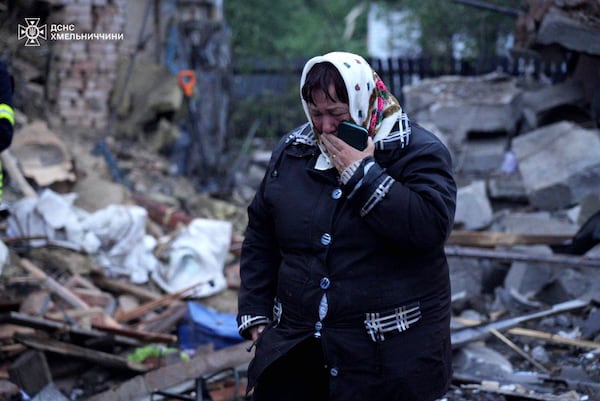 In this photo provided by the Ukrainian Emergency Service, a local resident cries standing amid the rubble of her house ruined after Russia's air attack in Khmelnytskyi region, Ukraine, Sunday, May 25, 2025. (Ukrainian Emergency Service via AP)