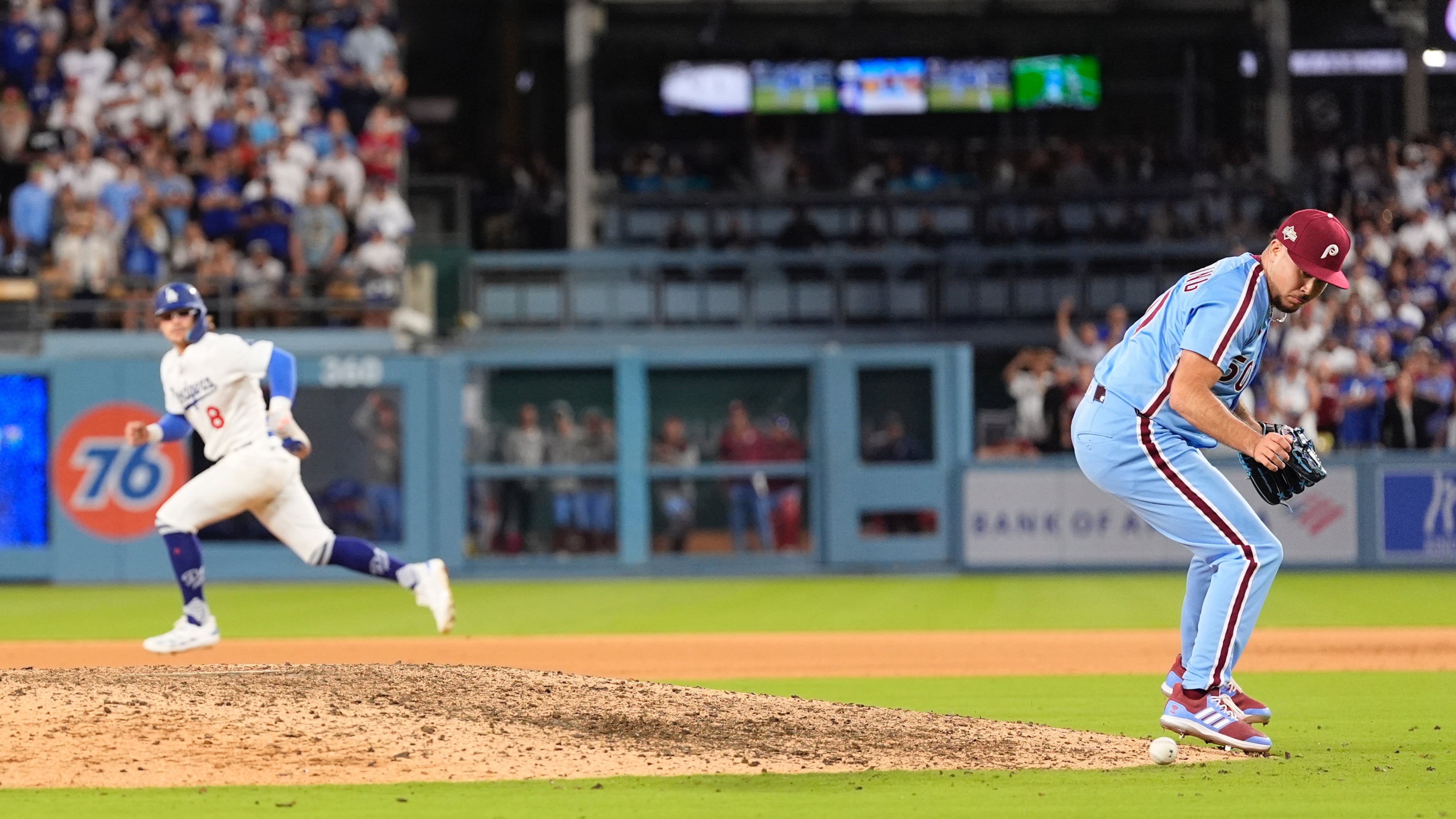Philadelphia Phillies pitcher Orion Kerkering looks down at a ground ball from Los Angeles Dodgers' Andy Pages before committing a throwing error to home platev and allowing the game-winning run to score during the eleventh inning in Game 4 of baseball's National League Division Series against the Los Angeles Dodgers, Thursday, Oct. 9, 2025, in Los Angeles. (AP Photo/Mark J. Terrill)