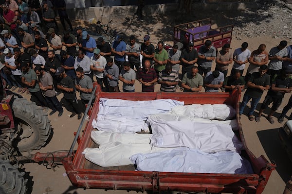 Mourners pray beside the bodies of Palestinians who were killed by an Israeli airstrike, during their funeral at Shifa Hospital in Gaza City Tuesday, July 15, 2025. (AP Photo/Jehad Alshrafi)