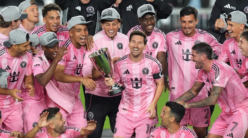 Inter Miami forward Lionel Messi (10) holds the trophy as Inter Miami players celebrate winning an MLS Eastern Conference final soccer match against New York City FC, Saturday, Nov. 29, 2025, in Fort Lauderdale, Fla. (AP Photo/Rebecca Blackwell)