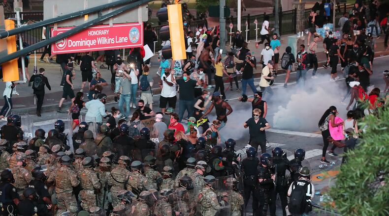 060220 Atlanta: Law enforcement officials and Georgia Army National Guard soldiers fire tear gas and advance on protesters on Centennial Olympic Park Drive outside the CNN Center at Olympic Park after curfew during a fifth day of protests over the death of George Floyd on Tuesday, June 2, 2020, in Atlanta.     Curtis Compton ccompton@ajc.com