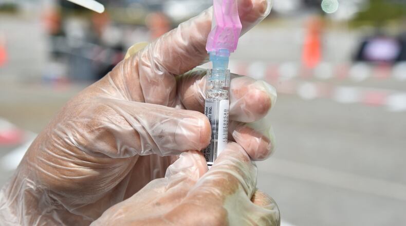 September 7, 2018 Atlanta - Claudina Prince RN, with DeKalb County Board of Health, prepares a flu shot for DeKalb County resident Tom Keating, 76, of Decatur, during the 2nd Annual Drive-Thru Flu Shot Clinic at parking lots of Northlake Mall on Friday, September 7, 2018. HYOSUB SHIN / HSHIN@AJC.COM