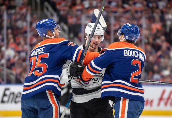 Los Angeles Kings' Adrian Kempe, center, Edmonton Oilers' Darnell Nurse (25) and OIlers' Evan Bouchard (2) rough it up during the first period of Game 3 of a first-round NHL hockey playoff series in Edmonton, Alberta, Friday, April 25, 2025. (Jason Franson/The Canadian Press via AP)