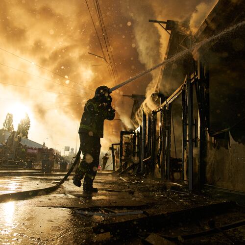 Firefighters try to put out a fire at a city book market following a Russian missile attack in Kyiv, Ukraine, early Sunday, Aug. 16, 2026. (AP Photo/Francisco Seco)