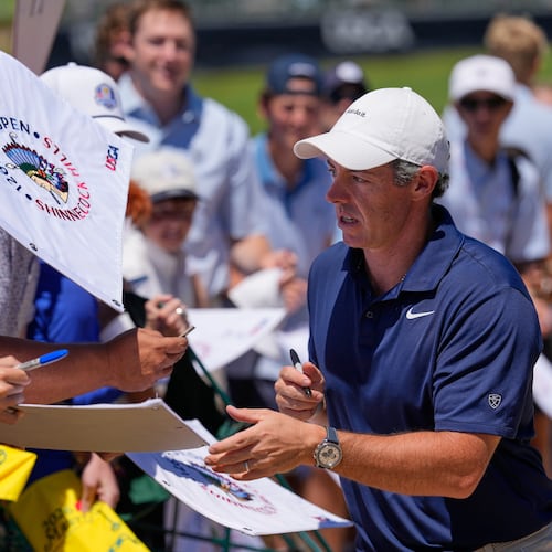 Rory McIlroy, of Northern Ireland, signs autographs during a practice round for the U.S. Open golf tournament at Shinnecock Hills Golf Club in Southampton, N.Y., Monday, June 15, 2026.(AP Photo/David J. Phillip)