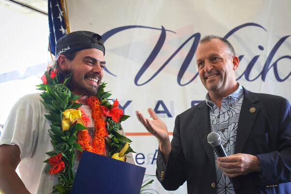 Governor Josh Green presents a proclamation to Oliver Widger, 29-year-old Oregon man who sailed from Oregon to Hawai'i, on Saturday, May 24, 2025 in Waikiki, Hawaii. (AP Photo/Michelle Bir)