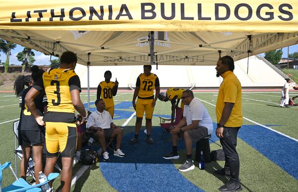 Lithonia football’s transformation began when coach Kevin Barnes (standing at right) arrived in 2024 and led the Bulldogs to a 6-4 record. (Hyosub Shin/AJC)