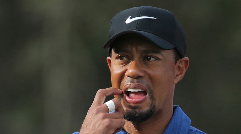 FILE - In this Feb. 2, 2017, file photo, Tiger Woods reacts on the 11th hole during the first round of the Dubai Desert Classic golf tournament in Dubai, United Arab Emirates. Woods pulled out of his next two tournaments because of ongoing back problems, a somber outlook for a 14-time major champion whose comeback barely lasted three tournaments before another setback. Woods said Friday, Feb. 10, 2017, on his website that he was still coping with back spasms that he attributed to his withdrawal from the Dubai Desert Classic last week. (AP Photo/Kamran Jebreili, File)