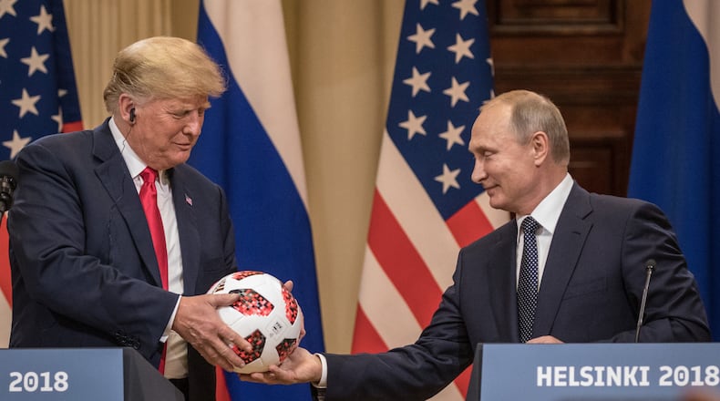 Russian President Vladimir Putin hands U.S. President Donald Trump a World Cup football during a joint press conference after their summit on Monday in Helsinki, Finland. Chris McGrath/Getty Images