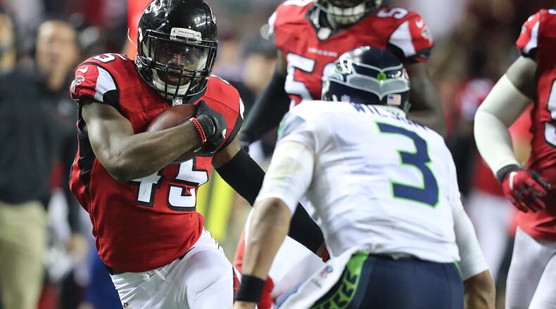 Falcons linebacker Deion Jones intercepts Seahawks quarterback Russell Wilson, who tries to make the tackle, in the final minutes of the fourth quarter to seal a 36-20 victory in a NFL football NFC divisional playoff game on Saturday, Jan. 14, 2017, in Atlanta.