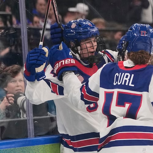 FILE - United States' Caroline Harvey celebrates with teammates after scoring her side's first goal during a preliminary round match of women's ice hockey between USA and Canada at the 2026 Winter Olympics, in Milan, Feb. 10, 2026. (AP Photo/Petr David Josek, File)