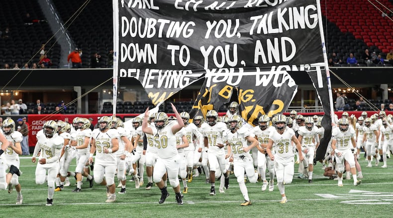 Calhoun players run onto the field before their game against Peach County during the Class AAA Championship at Mercedes-Benz Stadium Friday, December 8, 2017, in Atlanta. PHOTO / JASON GETZ