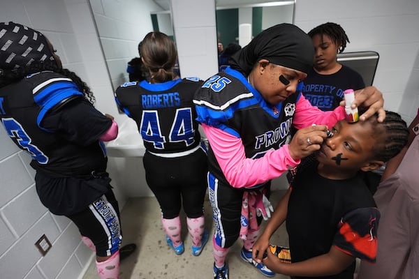 Detroit Prowl's Bugg Patman applies face paint to Jahi Tillman, as they prepare for an AWFL women's football game against the Lansing Legacy, in Allen Park, Mich., Saturday, May 10, 2025. (AP Photo/Paul Sancya)