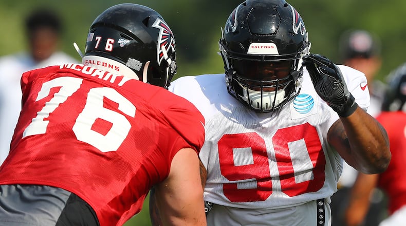Falcons defensive tackle Ra'Shede Hageman (right) rushes against rookie tackle Kaleb McGary during team practice Monday, July 29, 2019, in Flowery Branch.