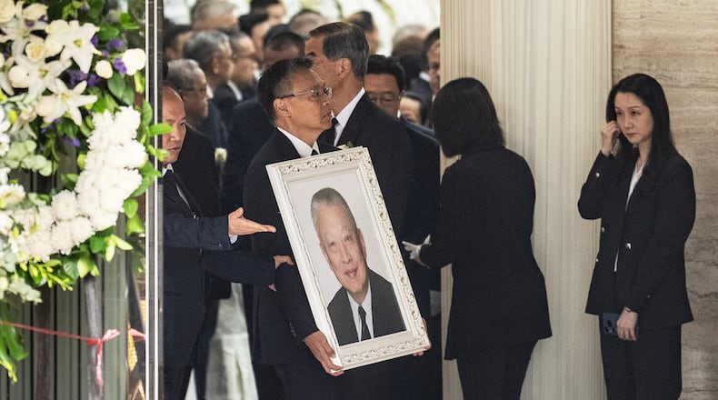 Andy Tung, son of former Hong Kong leader Tung Chee-hwa, carries his father's portrait at a funeral home in Hong Kong, Sunday, Sept. 20, 2026. (AP Photo/Chan Long Hei)