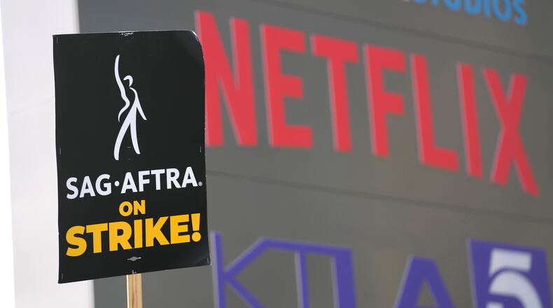 FILE - A picketer carries a sign on the picket line outside Netflix on Wednesday, Sept. 27, 2023, in Los Angeles. (AP Photo/Chris Pizzello, File)
