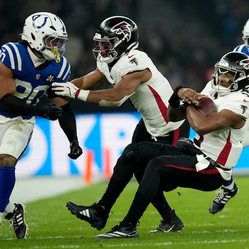 Atlanta Falcons quarterback Michael Penix Jr. (9) falls to the turf in front of Indianapolis Colts safety Nick Cross (20) during the first half of an NFL football game, Sunday, Nov. 9, 2025, in Berlin, Germany. (AP Photo/Ebrahim Noorozi)