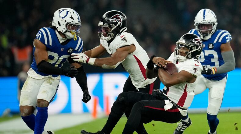 Atlanta Falcons quarterback Michael Penix Jr. (9) falls to the turf in front of Indianapolis Colts safety Nick Cross (20) during the first half of an NFL football game, Sunday, Nov. 9, 2025, in Berlin, Germany. (AP Photo/Ebrahim Noorozi)