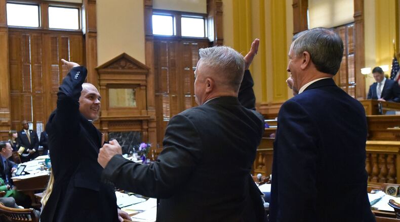 Sen. Bruce Thompson (left) high-fives Randy Robertson after the Senate voted on SB 163, which would let “home-schooled” students play on their local school’s athletic teams and participate in other extracurricular activities, on Thursday. It’s one of the various education-related bills still alive as the Georgia Legislature heads into the final days of this year’s session. HYOSUB SHIN / HSHIN@AJC.COM
