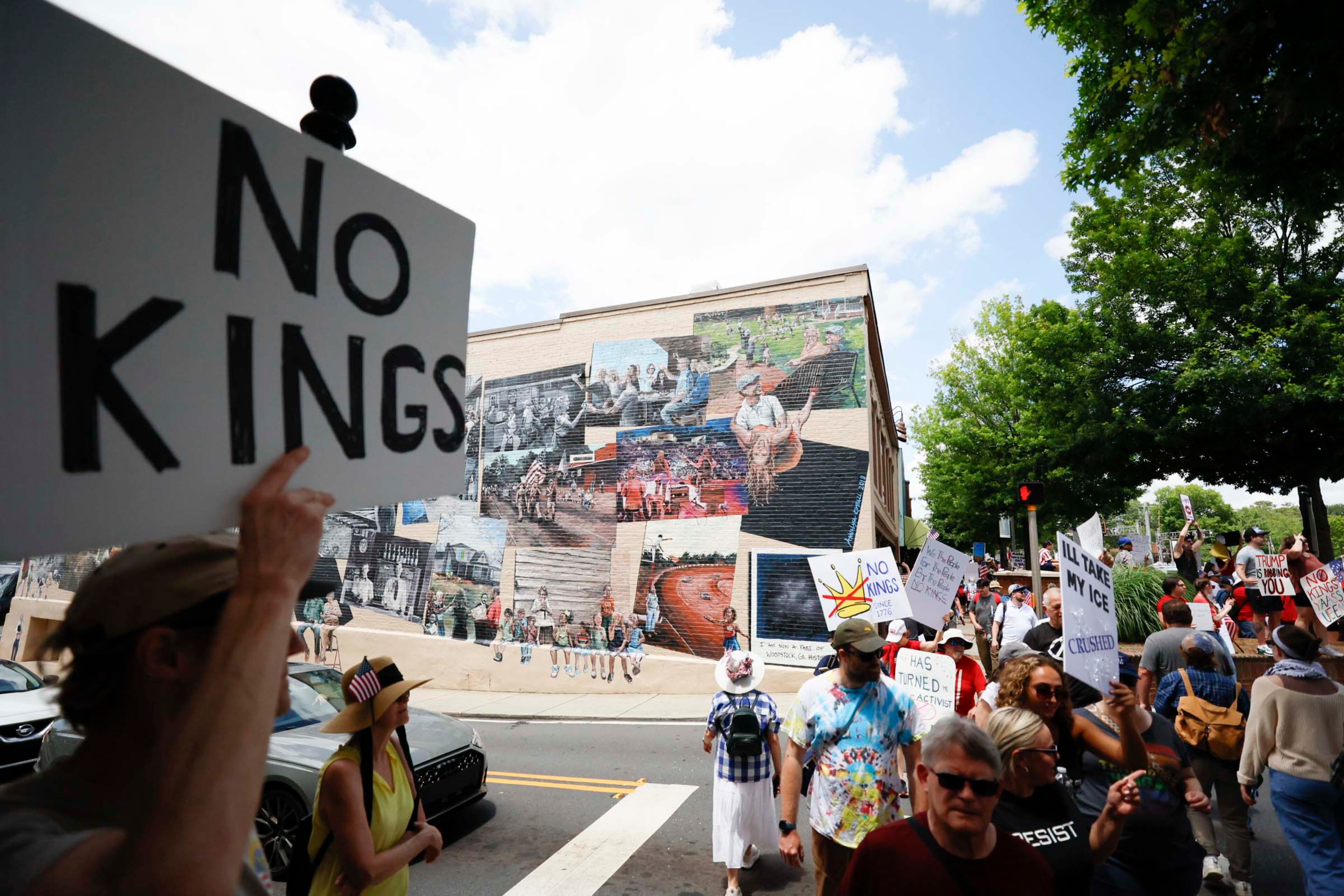 Demonstrators walk up and down Main Street as they rally in downtown Woodstock to protest the Trump administration's immigration enforcement policies on Saturday, June 14, 2025.
(Miguel Martinez/ AJC)
