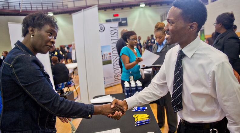 Pam Ambles (left) shakes hands with Kanod Covington as he attends the South Clayton Job Fair at the South Clayton Recreation Center in Hampton on Sept. 30.