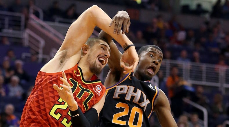 Hawks center Alex Len (25) gets tangled up with Phoenix Suns forward Josh Jackson (20) during the second half of an NBA basketball game Saturday, Feb. 2, 2019, in Phoenix. The Hawks defeated the Suns 118-112. (AP Photo/Ross D. Franklin)