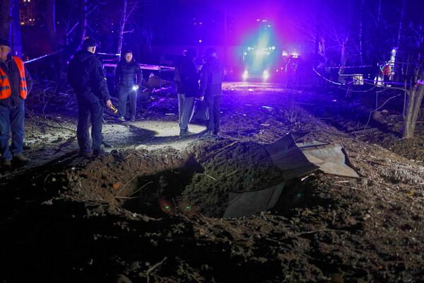 Police officers look at a crater made by a drone near apartment houses following Russia's night attack in Kharkiv, Ukraine, late Saturday, March 29, 2025. (AP Photo/Yevhen Titov)