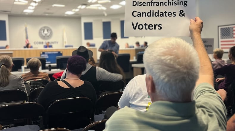Marietta resident Donald Barth holds a sign in protest at a Cobb County Board of Elections and Registration meeting on Tuesday, March 5, 2024 in Marietta. Barth was unable to qualify to run in District 2 because of the ongoing dispute over the county's electoral map. (Taylor Croft/taylor.croft@ajc.com)
