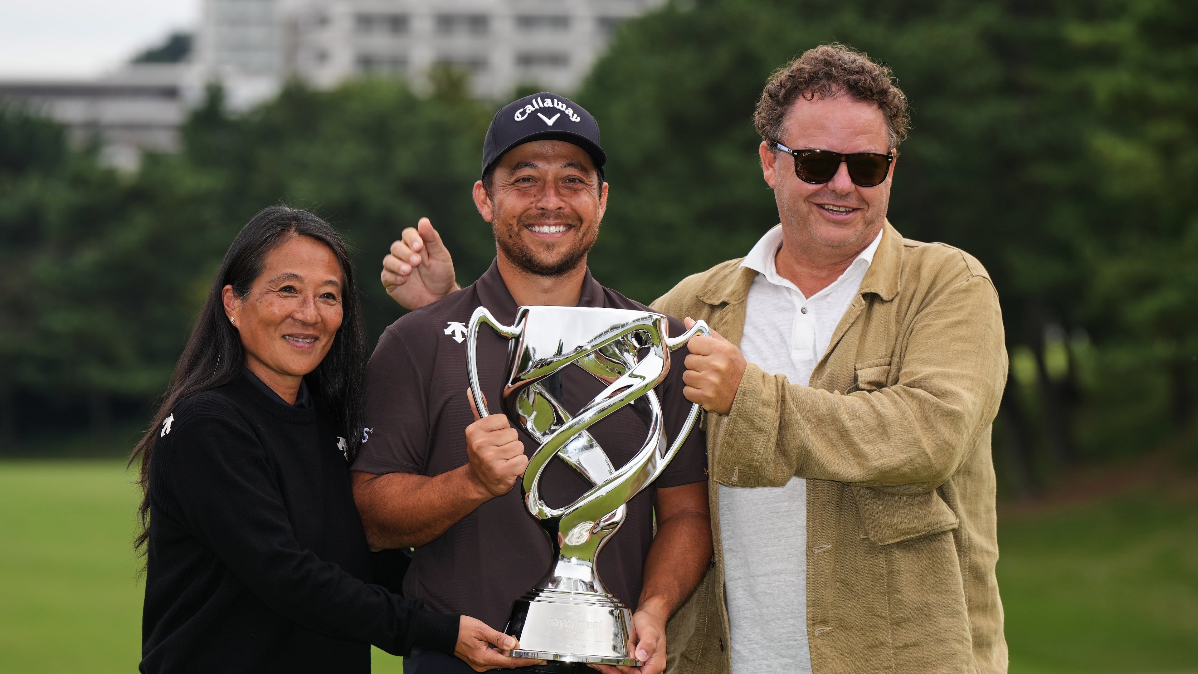 Xander Schauffele, of the U.S., poses for a photo with his parents, Chen Ping-Yi, left, and Stefan Schauffele, as he won the Baycurrent Classic golf tournament at the Yokohama Country Club in Yokohama, near Tokyo, Sunday, Oct. 12, 2025. (AP Photo/Hiro Komae)