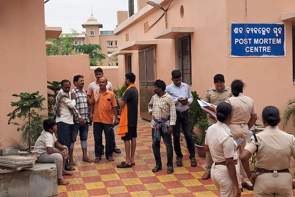 Police personnel and relatives of victims who lost their lives in a crowd surge at a Hindu religious procession wait outside a postmortem center at a government hospital in Puri, India, Sunday, June 29, 2025. (AP Photo)