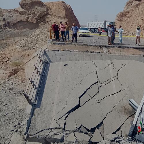 An overturned car sits on a section of a destroyed bridge after a strike in Hormozgan province, southern Iran, Saturday, July 18, 2026. (Mahdi Negahban/Mehr News Agency via AP)