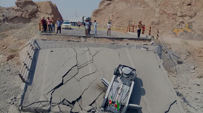 An overturned car sits on a section of a destroyed bridge after a strike in Hormozgan province, southern Iran, Saturday, July 18, 2026. (Mahdi Negahban/Mehr News Agency via AP)