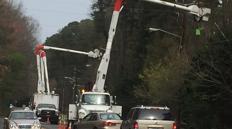 Crews work on power lines near Simpson Elementary School in Gwinnett County on Wednesday, March 22, 2017. The school temporarily lost power after storms swept through the area overnight. ERIC STIRGUS