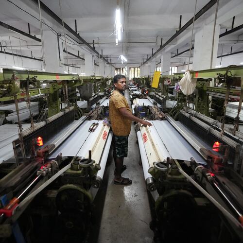 Migrant worker Sibaram Pradhan works at a power loom factory that produces polyester cloth in Surat, India, Thursday, May 28, 2026. (AP Photo/Ajit Solanki)