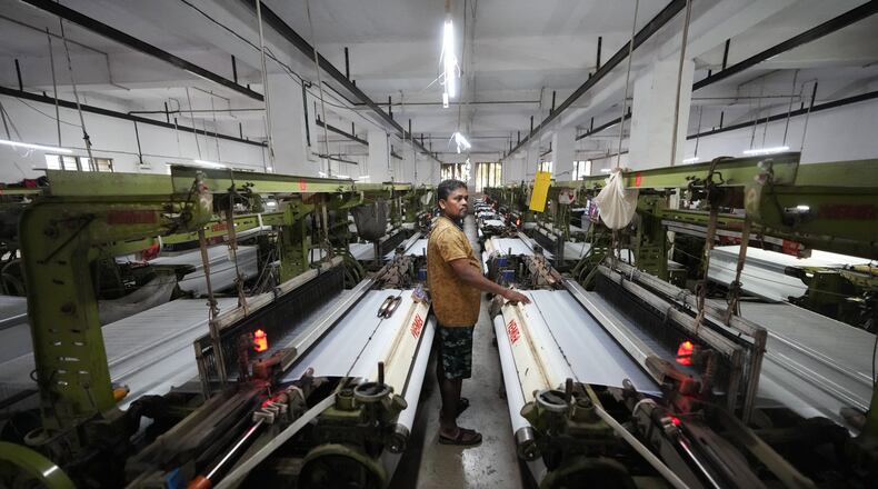 Migrant worker Sibaram Pradhan works at a power loom factory that produces polyester cloth in Surat, India, Thursday, May 28, 2026. (AP Photo/Ajit Solanki)