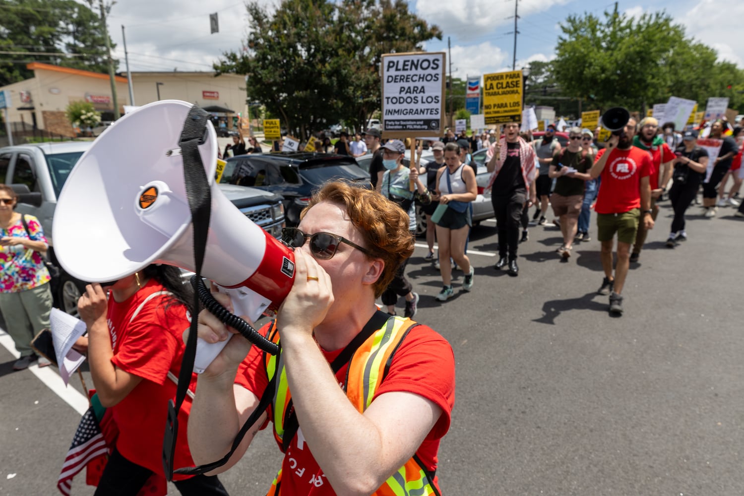 Demonstrators chant at police during a protest on ICE raids and deportation arrests on Chamblee-Tucker Road in Atlanta on Saturday, June 14, 2025. (Arvin Temkar / AJC)
