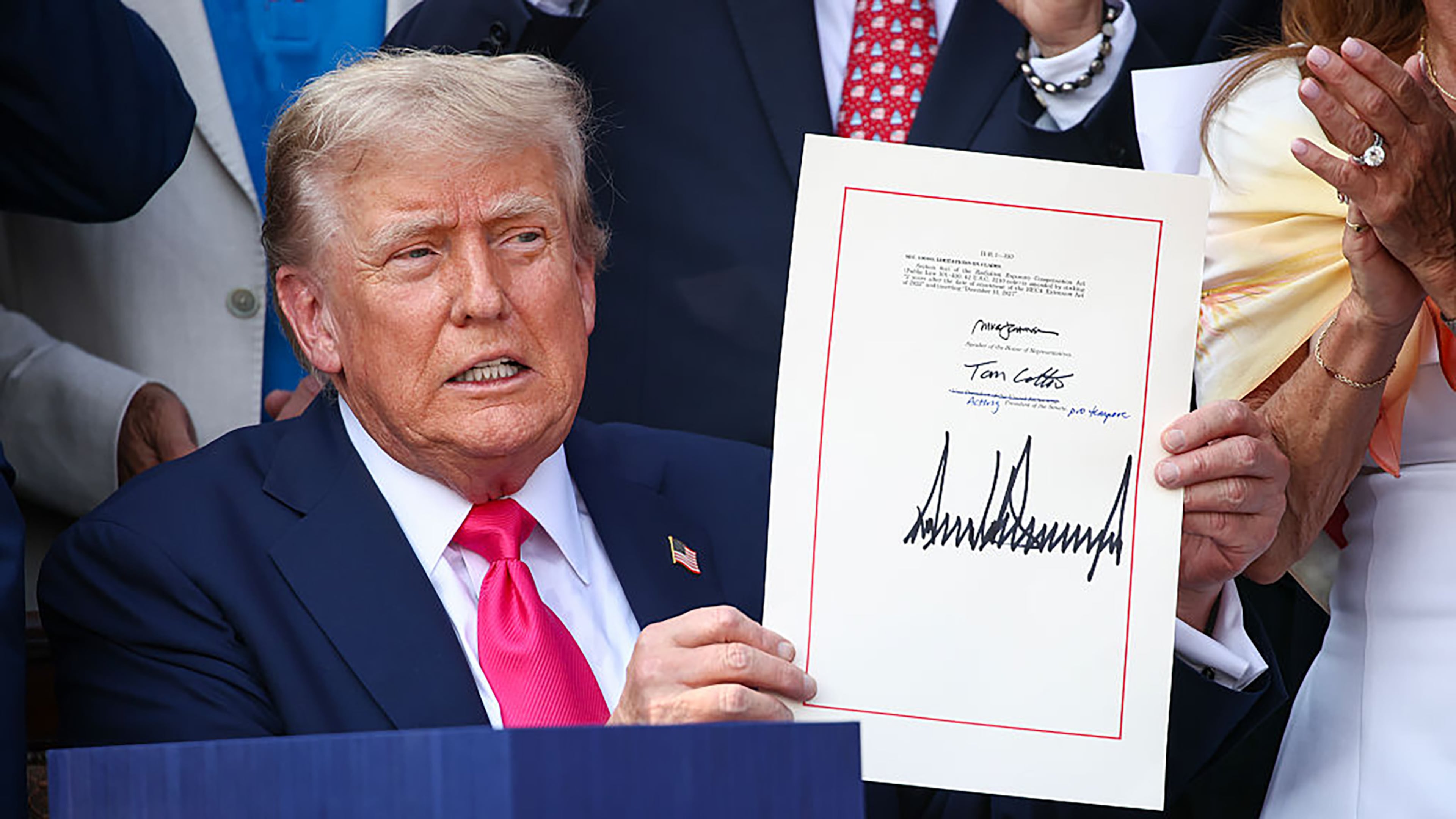 President Donald Trump signs the One Big Beautiful Bill Act into law during an Independence Day military family picnic on the South Lawn. (Samuel Corum/Getty Images/TNS)