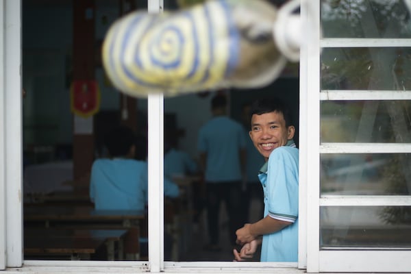 A boy smiles looking out of the window at a school for victims of Agent Orange in Da Nang, Vietnam, March 7, 2025. (AP Photo/Aniruddha Ghosal)