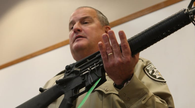 Former Cherokee County Sheriff Roger Garrison, displaying an AR-15 taken from a suspect's home. (Bob Andres/bob.andres@ajc.com)