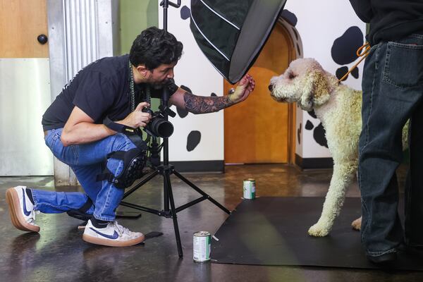 Diego Rodriguez's work uniform as a photographer consists of knee pads, a camera and a lanyard strung with animal call whistles. (Abbey Cutrer for the AJC)
