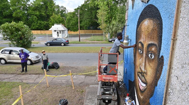May 15, 2020 Brunswick - Miami based artist Marvin Weeks, who is originally from Brunswick, works on a large mural in tribute to Ahmaud Arbery on the side of a building which will soon be the site of the Brunswick African American Cultural Center in Brunswick on Friday, May 15, 2020. Ahmaud Arbery was shot Feb. 23 as he jogged through Satilla Shores, a mostly white community a few miles from his Brunswick home. Security camera footage from a home under construction in the neighborhood where Ahmaud Arbery was shot to death in February shows a person who appears to be the same young man entering the property several times since last fall. (Hyosub Shin / Hyosub.Shin@ajc.com)
