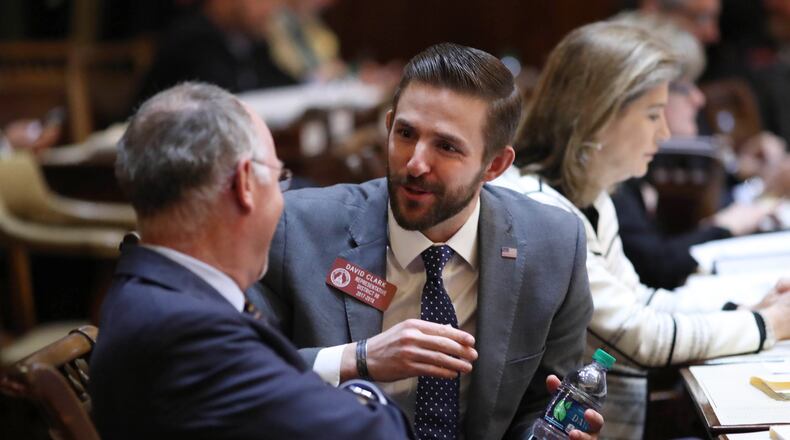 March 21, 2018 - Atlanta, Ga: Rep. David Clark, R-Buford, facing, talks with Rep. Allen Peake, R-Macon, in the House Chamber during legislative day 37 at the Georgia State Capitol Wednesday, March 21, 2018, in Atlanta. PHOTO / JASON GETZ